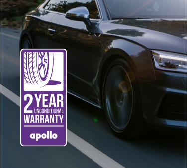 apollo warranty: a black car driving down the road with focus on the tyres.